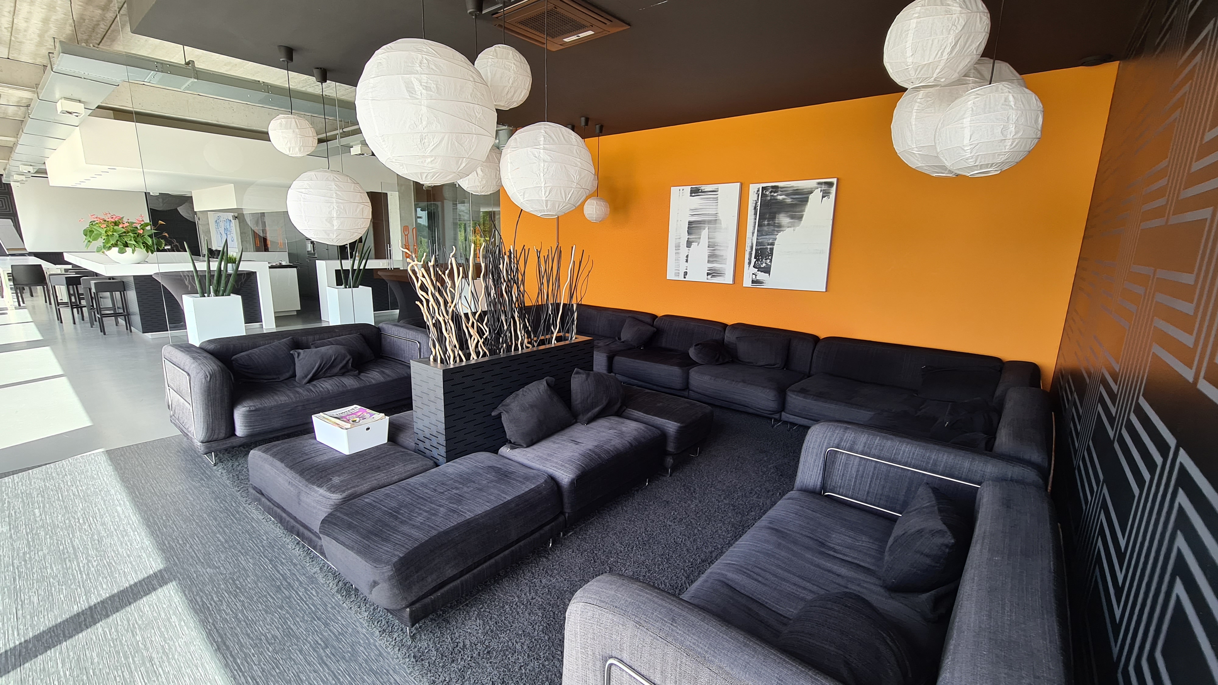 De lounge met comfortabele zetels en witte hanglampen